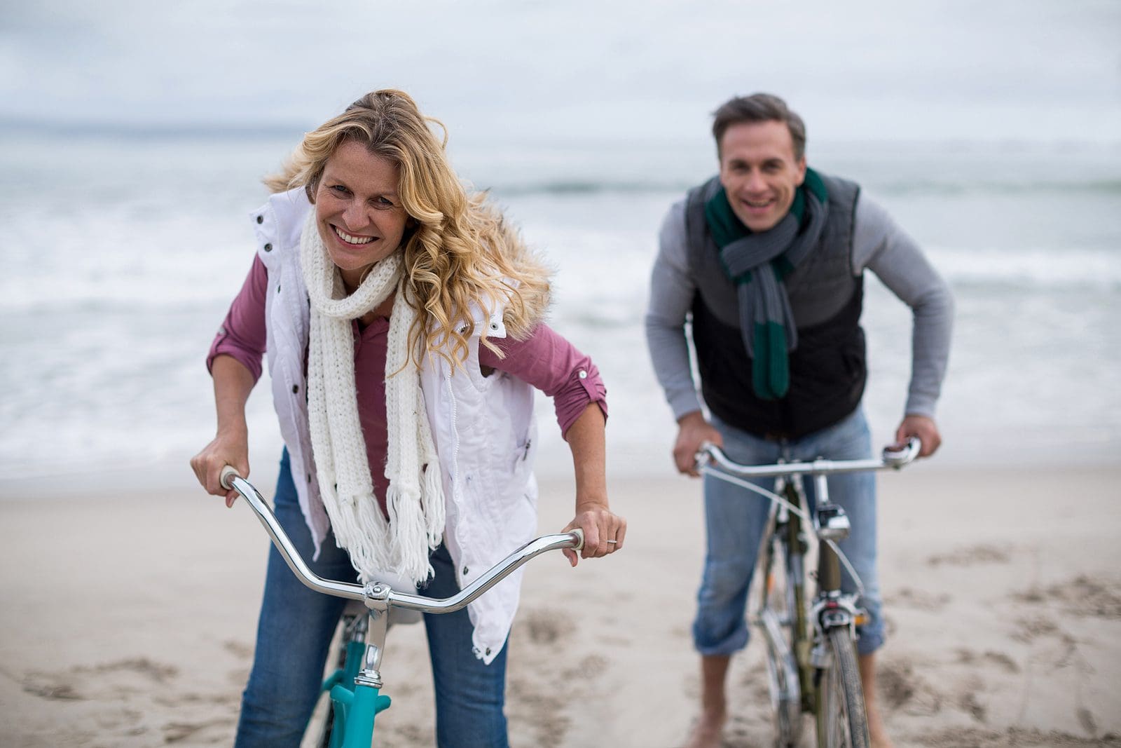 Portrait of mature couple riding bicycles on the beach